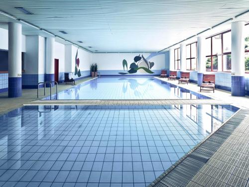 a large swimming pool in a large building at Mercure Jelenia Góra in Jelenia Góra