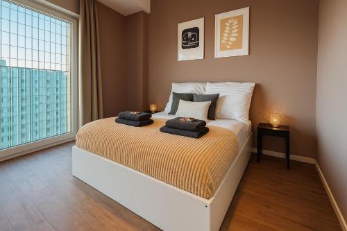 a bedroom with a bed with two towels on it at Homely! Skyview 2-Room Apartment, Airport, Fair, Rooftop, Gym! in Frankfurt/Main