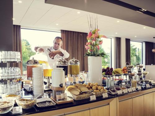 a man standing in front of a buffet of food at Mercure Gdynia Centrum in Gdynia