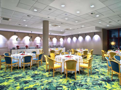 a dining room with tables and yellow chairs at Mercure Jelenia Góra in Jelenia Góra