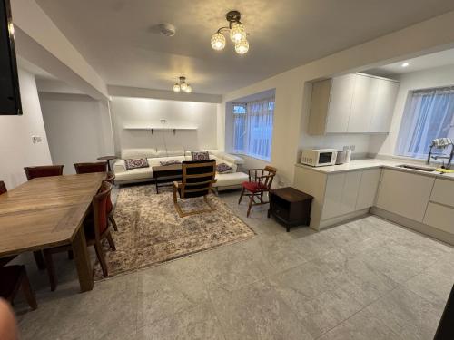 a kitchen and living room with a table and a couch at Bota Property in Kidlington