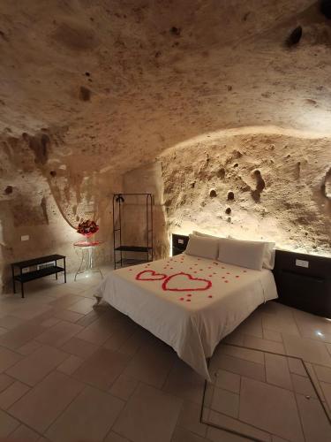 a bedroom with a bed in a stone wall at IL Nido nella Roccia in Matera