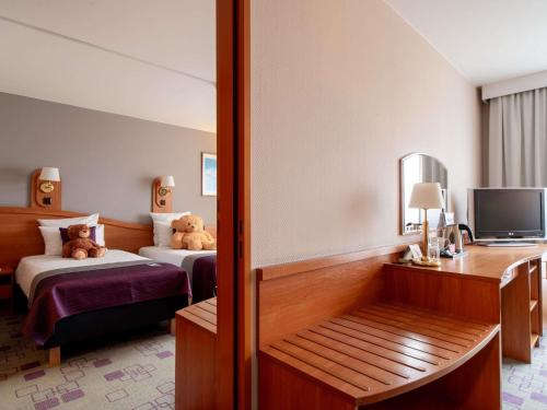 a hotel room with two beds with teddy bears on them at Mercure Cieszyn in Cieszyn