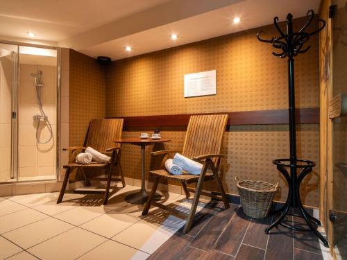 a bathroom with two chairs and a shower at Mercure Cieszyn in Cieszyn