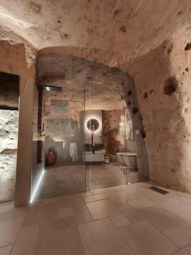 a room with a glass exhibit in a stone building at IL Nido nella Roccia in Matera