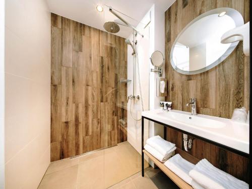 a bathroom with a sink and a mirror at Hotel Mercure Toruń Centrum in Toruń