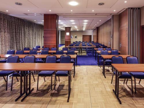 a conference room with wooden tables and chairs at Hotel Mercure Toruń Centrum in Toruń