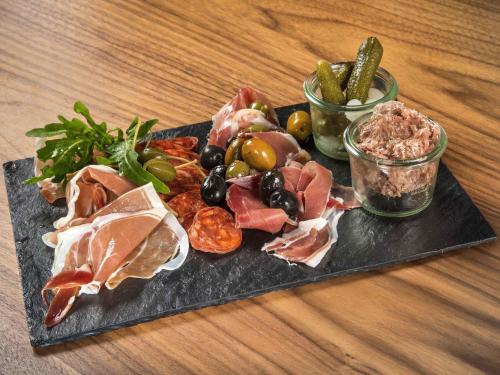 a plate of food with meat and vegetables on a table at Hotel Mercure Toruń Centrum in Toruń