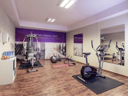 a gym with tread machines and exercise bikes in a room at Hotel Mercure Toruń Centrum in Toruń