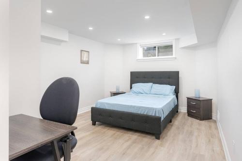 リッチモンドヒルにあるCozy 1BR Lower Level Walking distance to shopsのベッドと机と椅子のある寝室