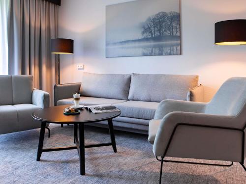a living room with a couch and a coffee table at Mercure Karpacz Skalny in Karpacz