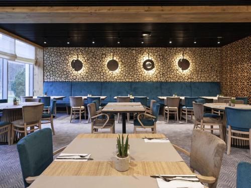 a dining room with tables and chairs and a wall with circles at Mercure Karpacz Skalny in Karpacz