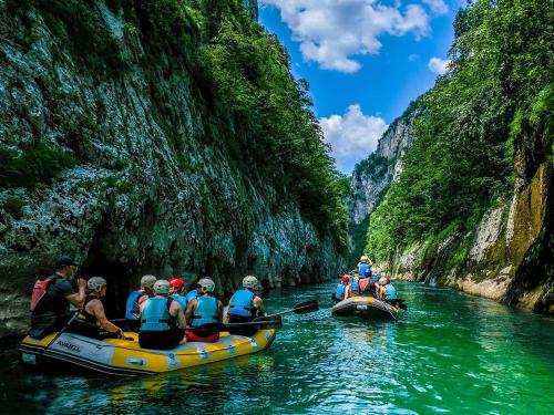 a group of people rafting down a river in a canyon at Vikend- kuća Konjic in Konjic