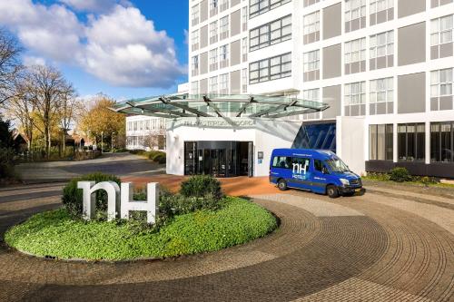 a blue van parked in front of a building at NH Amsterdam Noord in Amsterdam