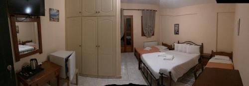 a small room with two beds and a television at HOTEL ΗΩ (ΞΕΝΩΝΑΣ ΤΣΙΑΧΡΗΣ) in Morfovoúnion