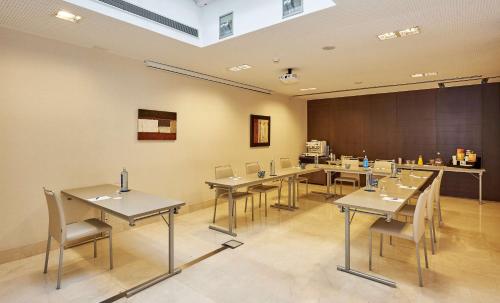 a classroom with tables and chairs and a chalkboard at NH Sants Barcelona in Barcelona