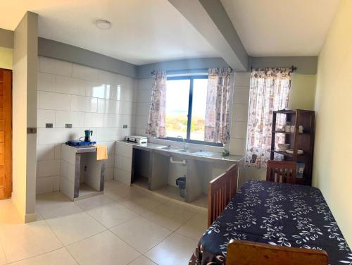 a kitchen with a sink and a table in a room at Alojamiento Bilbao in Quillacollo