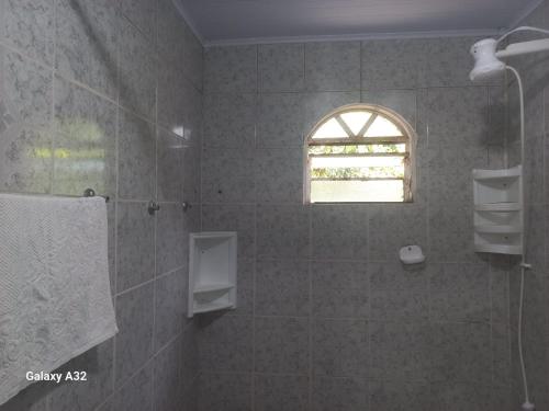 a bathroom with a shower and a window at Casa da Vó Nair in Iporanga