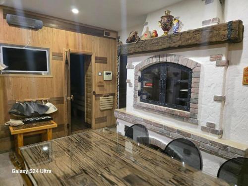 a living room with a stone fireplace and a table at Sarafovo ATLANTIS 58 in Burgas City