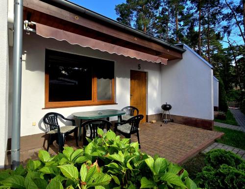 a patio with a table and chairs in front of a house at Monti Domki całoroczne in Mierzyn