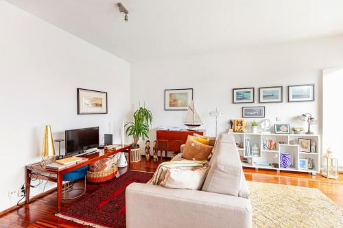 a living room with a couch and a tv at Porto D´Ouro Apartments in Porto
