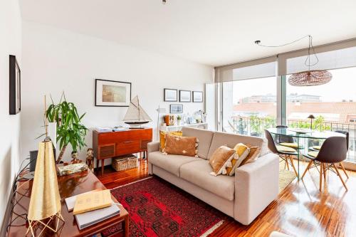 a living room with a couch and a glass table at Porto D´Ouro Apartments in Porto