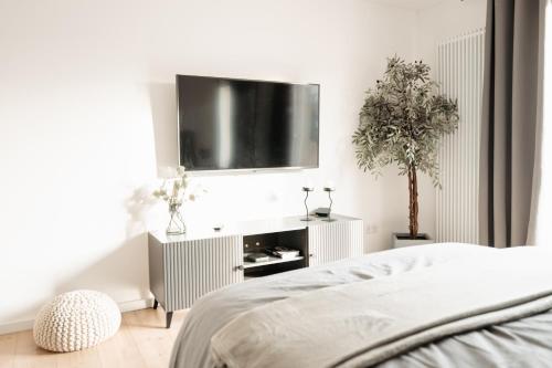a bedroom with a bed and a flat screen tv at Elegantes Apartment mit Terrasse in Bad Pyrmont