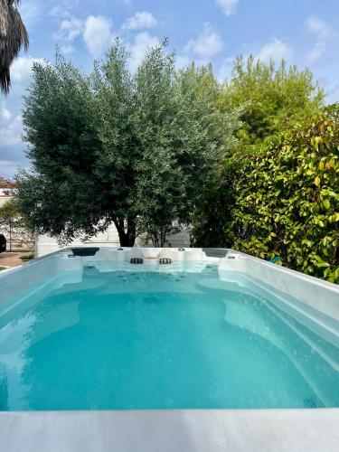 a large blue pool with a tree in the background at Villa Damare in Taranto