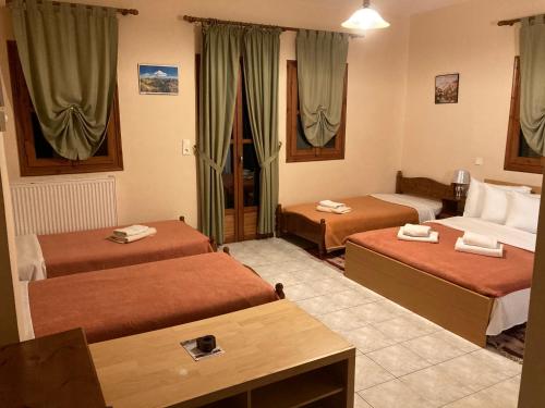 a hotel room with two beds and a couch at HOTEL ΗΩ (ΞΕΝΩΝΑΣ ΤΣΙΑΧΡΗΣ) in Morfovoúnion