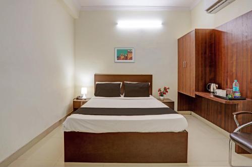 a bedroom with a large bed in a room at Hotel O Shiridi Residency in Vidya Nagar