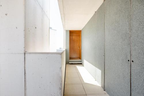 a hallway with white walls and a wooden door at Porto D´Ouro Apartments in Porto
