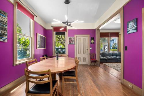 a dining room with purple walls and a wooden table at Charming 5 BD Victorian House by Beach Boardwalk in Santa Cruz