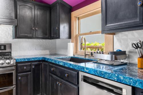 a kitchen with black cabinets and a sink and a window at Charming 5 BD Victorian House by Beach Boardwalk in Santa Cruz