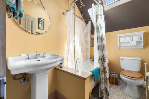 a bathroom with a sink and a toilet and a mirror at Charming 5 BD Victorian House by Beach Boardwalk in Santa Cruz