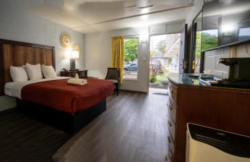a hotel room with a bed and a kitchen at Heart of Manteo in Manteo