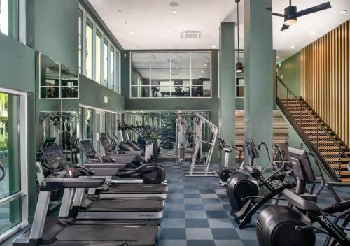 a gym with a row of treadmills and machines at Sunlit Retreat 10 Min from Disneyland With Pool & GYM in Tustin