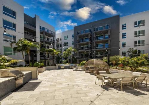 a patio with tables and chairs in front of a building at Sunlit Retreat 10 Min from Disneyland With Pool & GYM in Tustin