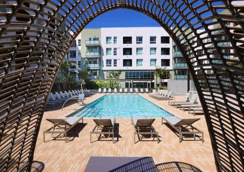 an archway with chairs and a pool and buildings at Sunlit Retreat 10 Min from Disneyland With Pool & GYM in Tustin