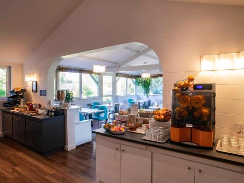 a lobby with a cafeteria with a counter with food at ibis Styles Quimper in Quimper