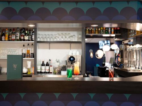 a bar with a counter with drinks on it at ibis Styles Quimper in Quimper