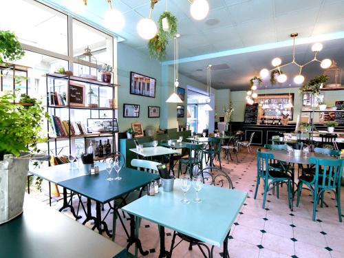 a dining room with blue tables and chairs at ibis Nantes Saint Herblain in Saint-Herblain