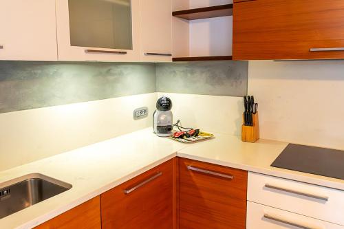 a kitchen with white counter tops and wooden cabinets at Appartamento Nonna Rosa in Tirano