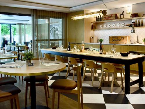 a restaurant with tables and chairs in a room at ibis Maisons Laffitte in Maisons-Laffitte