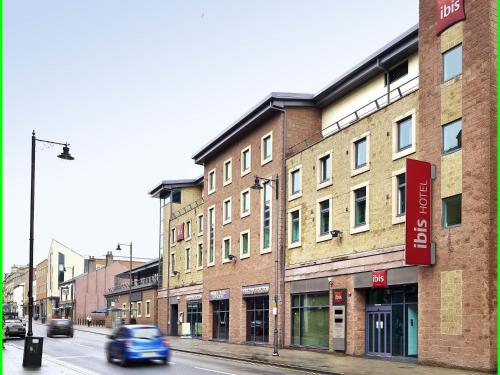 a car driving down a street next to a building at ibis Carlisle City Centre in Carlisle