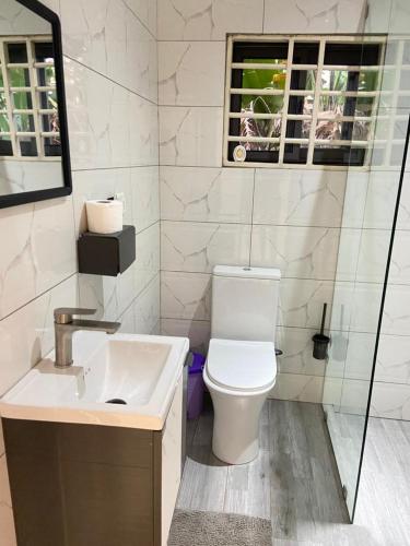 a white bathroom with a toilet and a sink at 2BR House in Gbawe in Gbawe