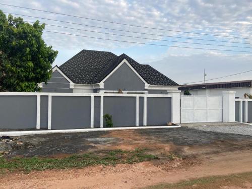 a house with a white fence and a garage at 2BR House in Gbawe in Gbawe