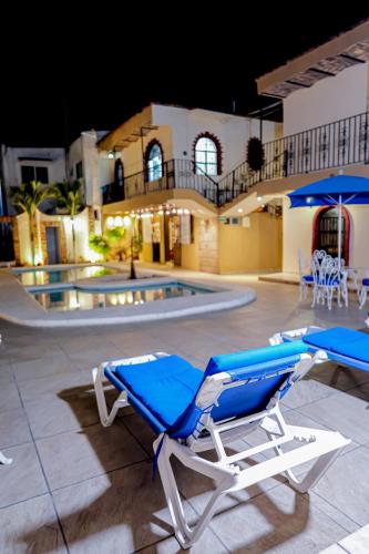 a blue and white lounge chair next to a swimming pool at Bungalows Maria Teresa in Rincon de Guayabitos