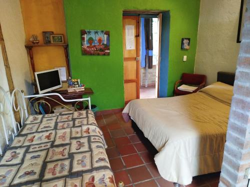 a bedroom with two beds and a computer on a desk at HOSTAL CASA DE GUADUA/ THE BAMBOO HOUSE in Choachí