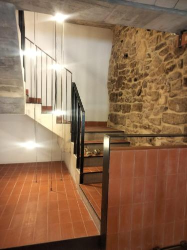 a room with a stone wall and a staircase at Hostal Boutique Restaurante El Algars in Caseras