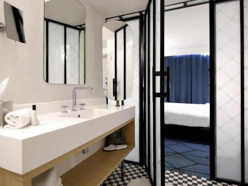 a bathroom with a sink and a mirror at Mercure Nantes Centre Gare in Nantes